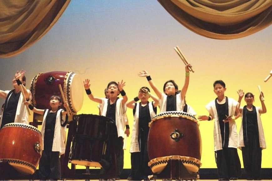 子供たちが笑顔で太鼓を叩いている様子